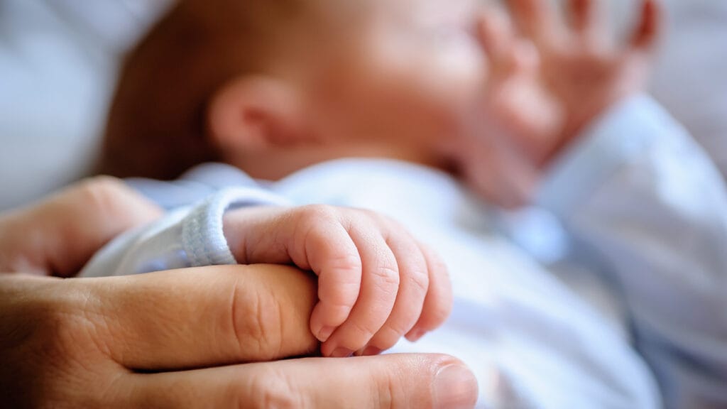 Vastasyntyneen vauvan sormet puristavat äidin sormea.